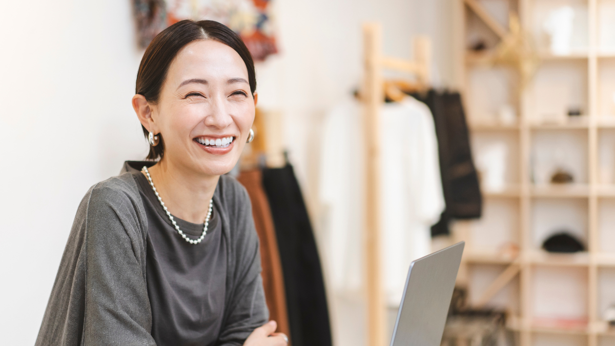 笑顔で相談に応じる女性スタッフがパソコンの前で顧客対応している様子